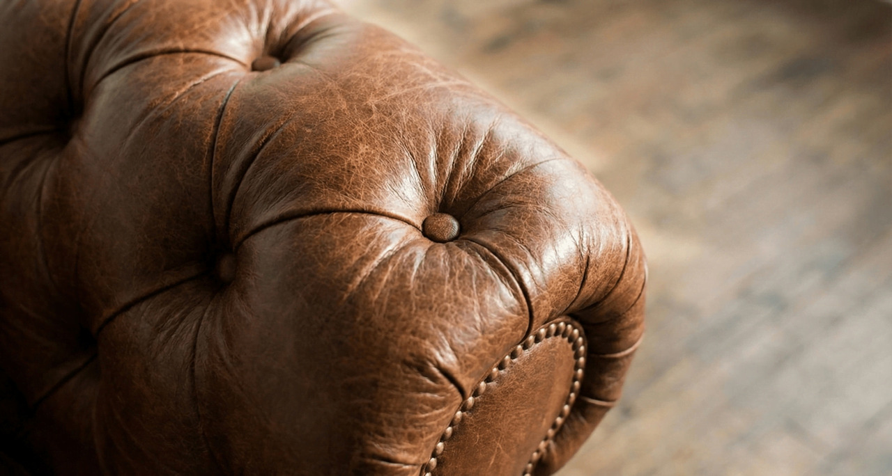 detailed-view-of-a-brown-leather-chesterfield-arm-with-button-tufting-1